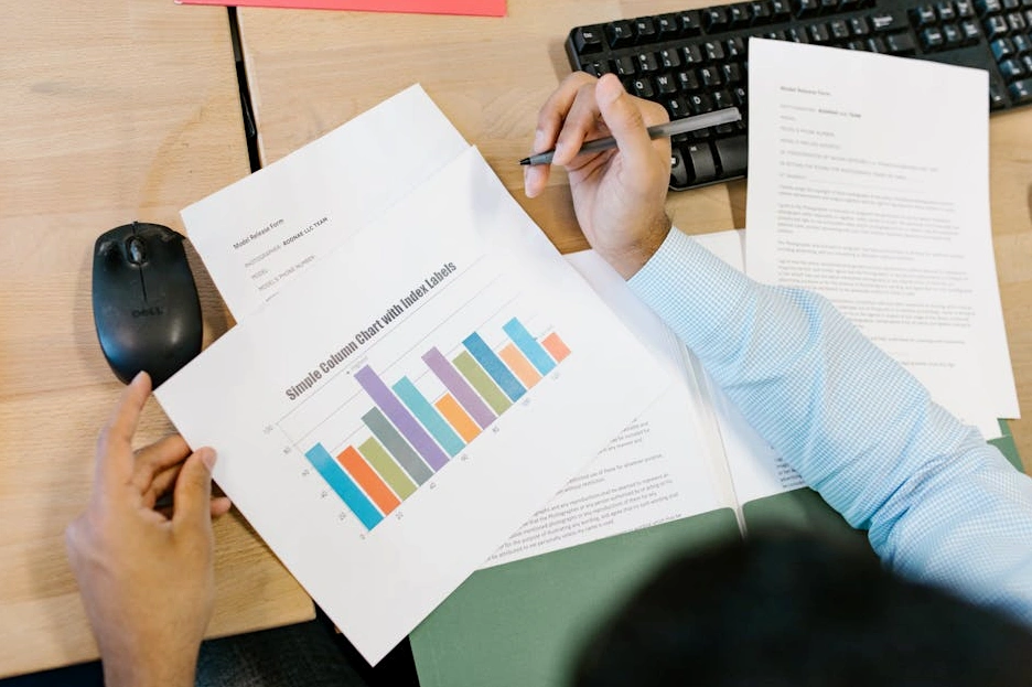 Analityk pracujący nad wykresem finansowym na laptopie.